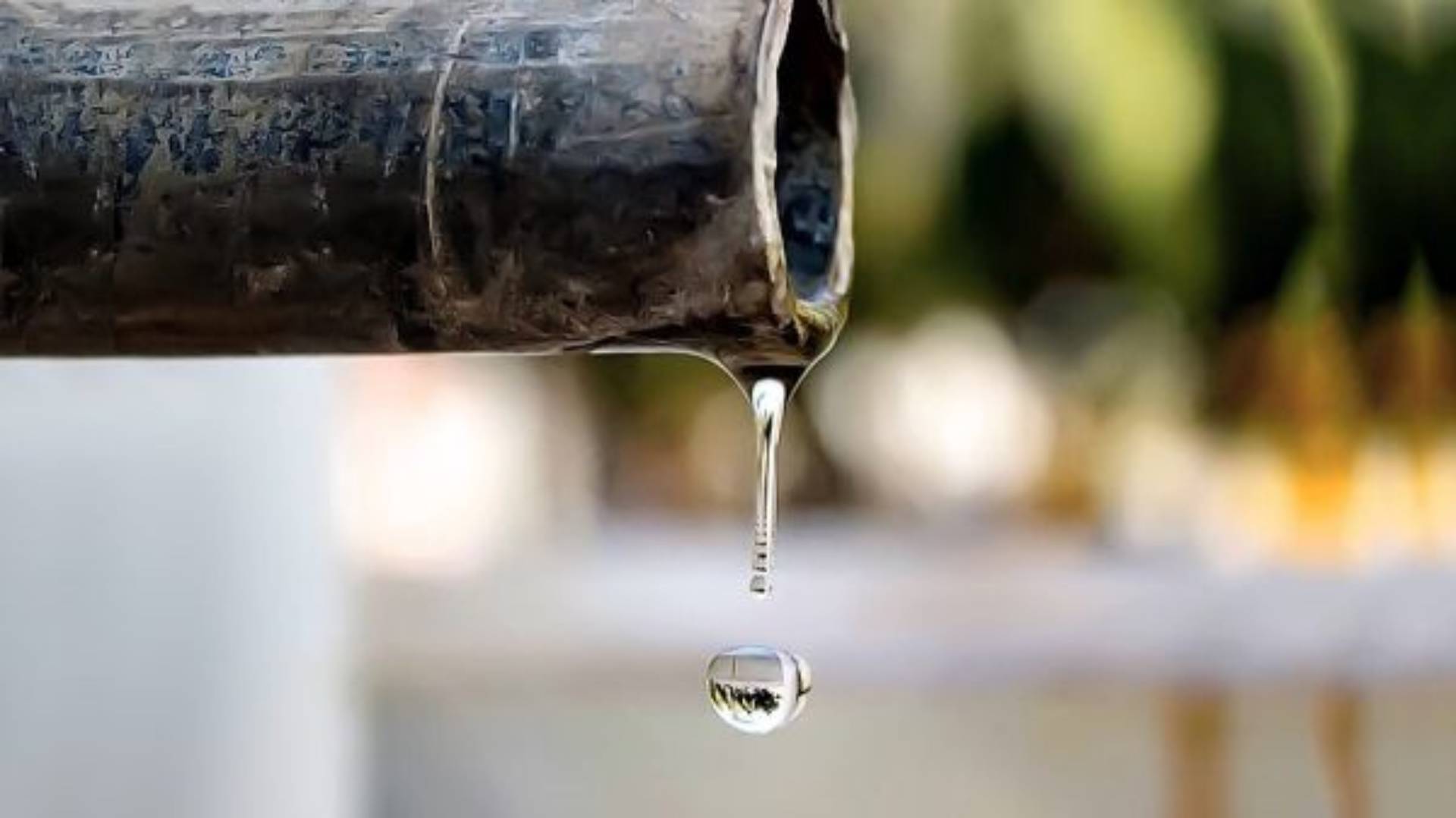 drop of water falling from metal pipe