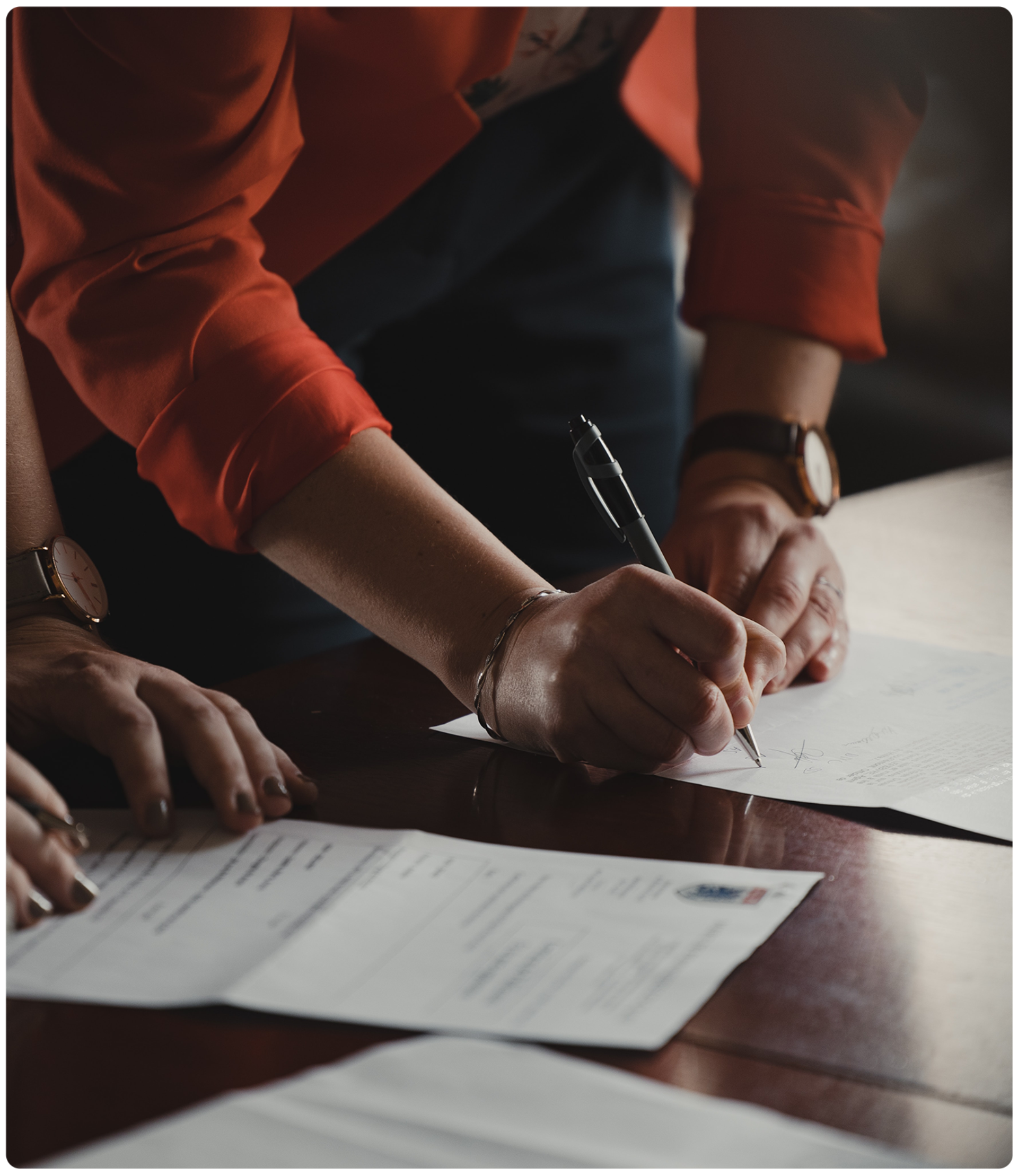 person signing document with pen